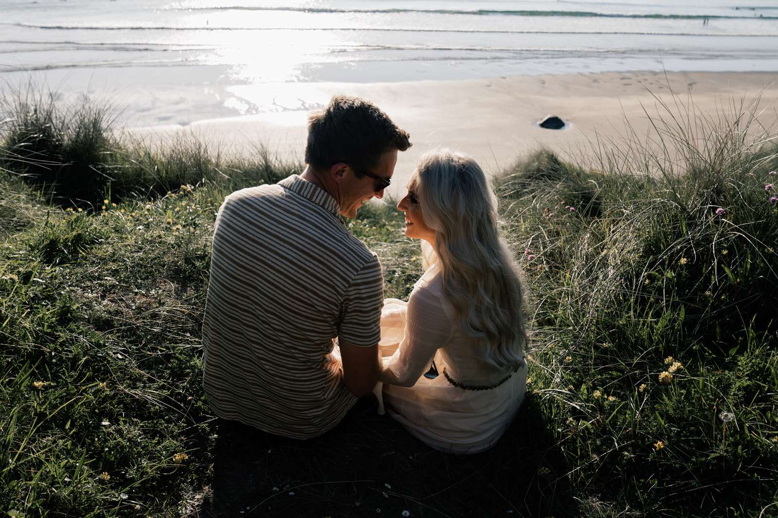 A couple sitting in the dunes of Whitesands beach