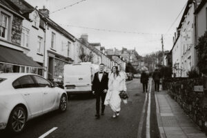 Couple walk through newport Pembrokeshire, on their wedding day, 